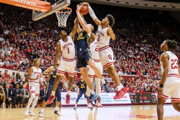 Two Indiana Hoosiers basketball players block shot from opponent